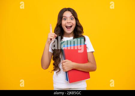 Amazed teen girl. Teenager school girl with books isolated studio background. Excited expression, cheerful and glad. Stock Photo