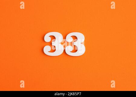 Number 33 - On orange foam rubber background Stock Photo