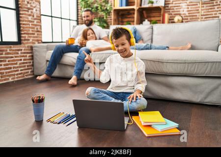 Family of three doing homework at home smiling happy pointing with hand and finger to the side Stock Photo