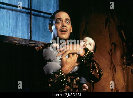 Raul Julia & Baby Film: Addams Family Values (USA 1993) Characters: Gomez Addams &  Director: Barry Sonnenfeld 19 November 1993   **WARNING** This Photograph is for editorial use only and is the copyright of PARAMOUNT PICTURES and/or the Photographer assigned by the Film or Production Company and can only be reproduced by publications in conjunction with the promotion of the above Film. A Mandatory Credit To PARAMOUNT PICTURES is required. The Photographer should also be credited when known. No commercial use can be granted without written authority from the Film Company. Stock Photo