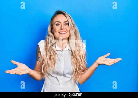 Beautiful young blonde woman wearing casual white shirt clueless