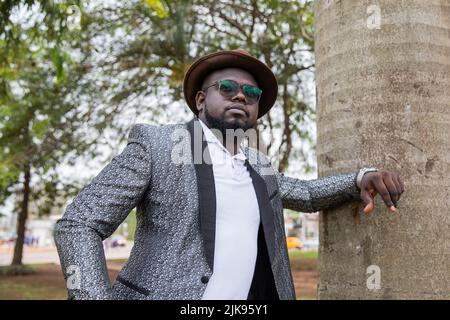 Young thoughtful African man poses in his city park. Loneliness concept. Stock Photo