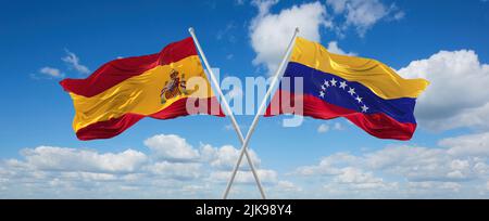 Venezuela and Spain flags waving together in the wind on blue cloudy ...