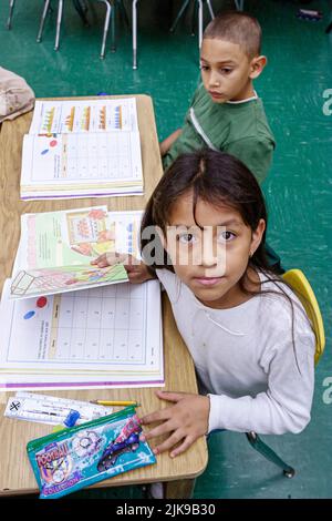 Miami Florida,Frederick Douglass Elementary School,low income neighborhood community,Hispanic students girl boy children classroom desk workbook book Stock Photo
