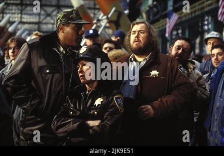 Rhea Perlman & John Candy Film: Canadian Bacon (1995) Characters: Honey, Sheriff Bud Boomer  Director: Michael Moore 08 June 1995   **WARNING** This Photograph is for editorial use only and is the copyright of POLYGRAM VIDEO and/or the Photographer assigned by the Film or Production Company and can only be reproduced by publications in conjunction with the promotion of the above Film. A Mandatory Credit To POLYGRAM VIDEO is required. The Photographer should also be credited when known. No commercial use can be granted without written authority from the Film Company. Stock Photo