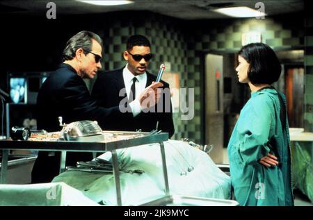 Tommy Lee Jones, Will Smith & Linda Fiorentino Film: Men In Black (USA 1997) Characters: Agent K (Kay),James Edwards,Dr. Laurel Weaver  Director: Barry Sonnenfeld 02 July 1997   **WARNING** This Photograph is for editorial use only and is the copyright of COLUMBIA PICTURES and/or the Photographer assigned by the Film or Production Company and can only be reproduced by publications in conjunction with the promotion of the above Film. A Mandatory Credit To COLUMBIA PICTURES is required. The Photographer should also be credited when known. No commercial use can be granted without written authorit Stock Photo