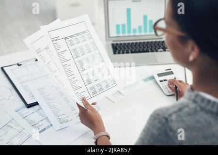 Reviewing her documents needed for filing. Closeup shot of an unrecognisable businesswoman calculating finances in an office. Stock Photo