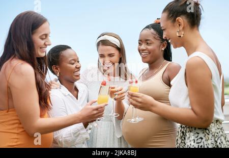 Cheers to you and your little one. a group of female friends toasting to their pregnant friend at a baby shower. Stock Photo