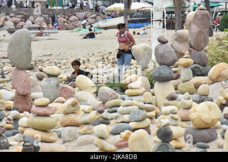 Puerto Vallarta, Mexico City, Jalisco. 31st July, 2022. July 31, 2022, Puerto Vallarta, Mexico: Tourists enjoy taking part during the installation of stack stones, a tourist attraction on the boardwalk of Puerto Vallarta on the Pacific coast of Mexico. on July 31, 2022 in Puerto Vallarta, Mexico. (Credit Image: © Carlos Tischler/eyepix via ZUMA Press Wire) Stock Photo