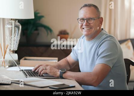 I love being able to work from home. a mature man typing on his laptop. Stock Photo