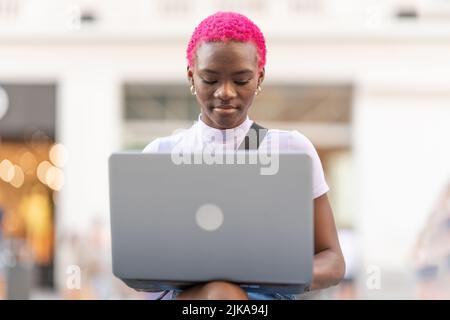 Portrait of a young african woman using the laptop outdoors Stock Photo