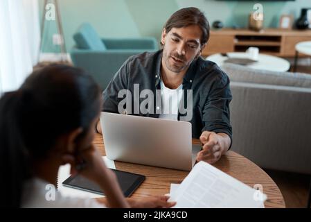 Its not that much to read. a young couple doing paperwork while using a laptop at home. Stock Photo