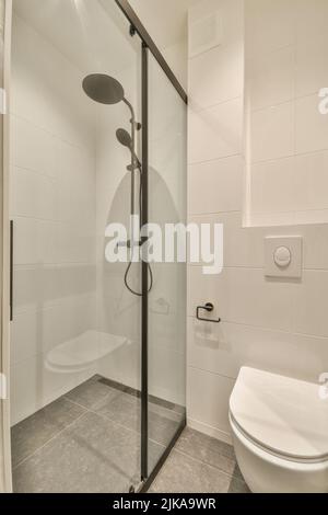 Stylish bathroom interior design with white toilet and shower cabin with glass shower in modern apartment Stock Photo