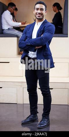 Standing tall and proud in my position as CEO. Full length shot of a handsome young businessman standing in the office with his arms folded. Stock Photo