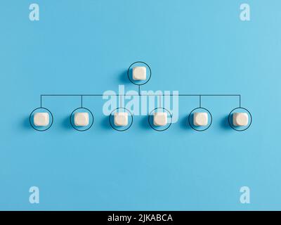 Blank company hierarchical organizational chart of wooden cubes on blue background. Human resources management and business concept Stock Photo
