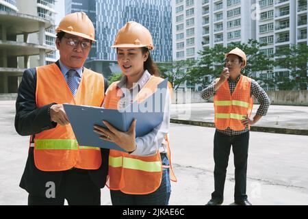 Investor and engineer discussing document at the site Stock Photo