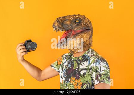 Man using professional camera wearing animal head mask isolated on yellow background.Photographer studio concept. Stock Photo