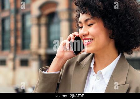 latin woman smiling happy talking on the phone Stock Photo