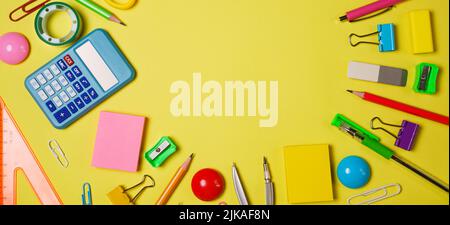 Creative and trendy, school or office workspace with colored supplies on a yellow background. Flat layout. Stock Photo
