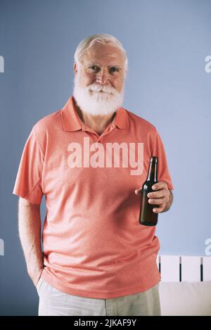 Portrait of handsome elderly man posing with beer bottle in his hand Stock Photo