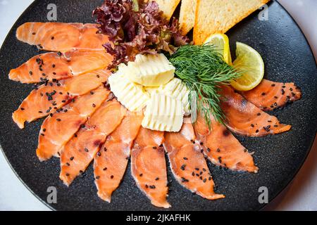 Lightly salted salmon slices with butter and wheat toasts Stock Photo