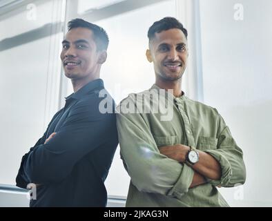 Hes got my back, and Ive got his. Cropped portrait of two handsome young businessmen standing back to back with their arms folded in their office. Stock Photo