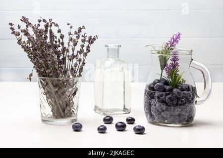 Sparkling blueberry water in glass jar. Lavender in glass. Water in bottle. White background. Stock Photo