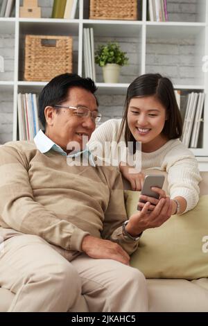 Vietnamese father and daughter using mobile application Stock Photo