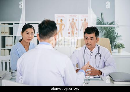 Doctor conducting meeting with his coworkers in office Stock Photo