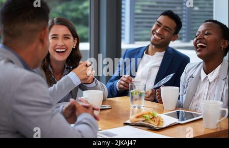 Alone, we can do little, together well do so much. a group of colleagues having a meeting and breakfast in a modern office. Stock Photo