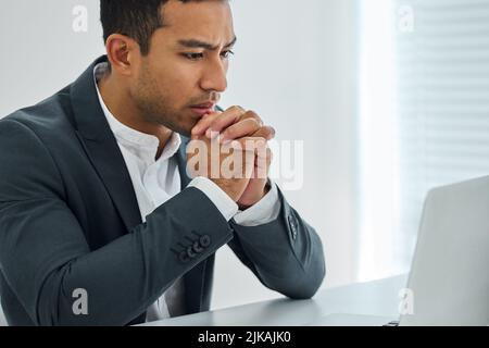 Spirit not broken, wiser than before. a businessman looking worried while using his laptop at his desk in a modern office. Stock Photo