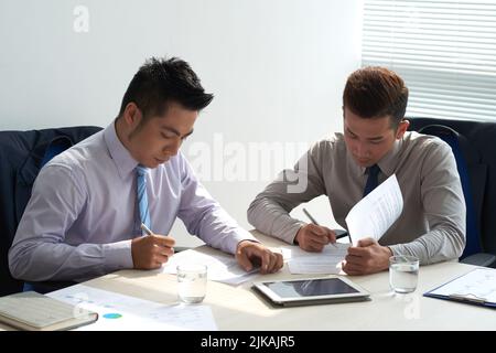 Business people carefully reading agreements before signing it Stock Photo