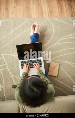 Young woman with laptop sitting on the floor Stock Photo