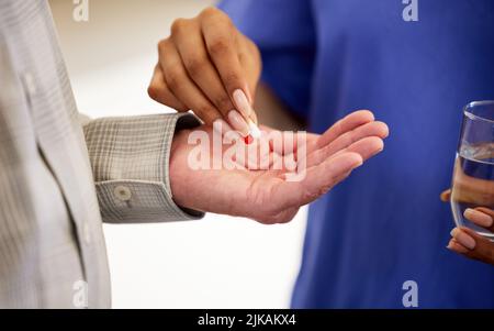 take these every 3 hours. a nurse giving her patient pills. Stock Photo