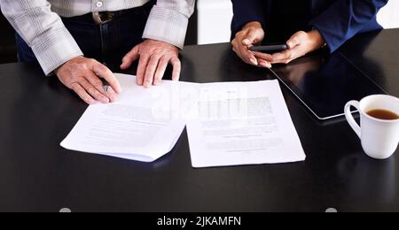 Making sure his finances are enough to carry him through. High angle shot of an unrecognizable female broker and her male client going over some Stock Photo