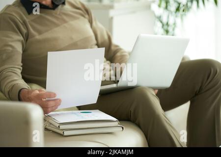 Cropped image of businessman working with documents at home Stock Photo