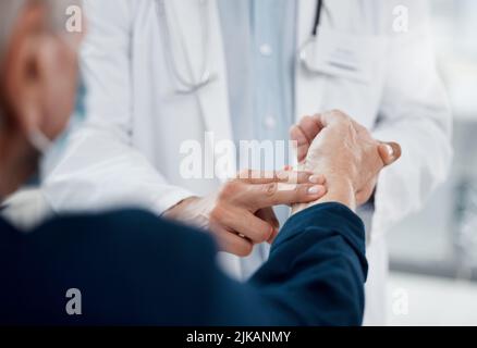 Your pulse seems normal. an unrecognizable doctor checking a patients pulse in an office. Stock Photo