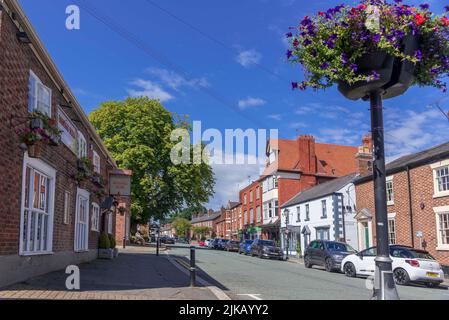 The High stret in Tarporle, Cheshire with the Rising Sun pub on the left. Stock Photo