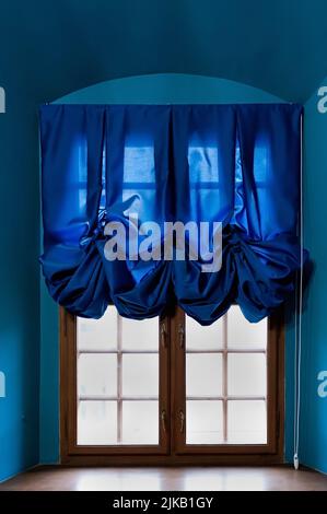 Closeup of an old window with blue curtains Stock Photo