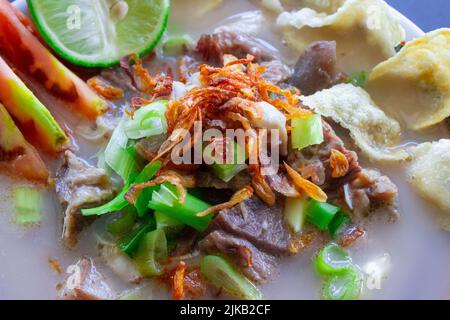 sop kaki kambing a traditional food from Betawi, Jakarta Indonesia, made from mutton or lamb, offal, spices. isolated on black background.This food Stock Photo