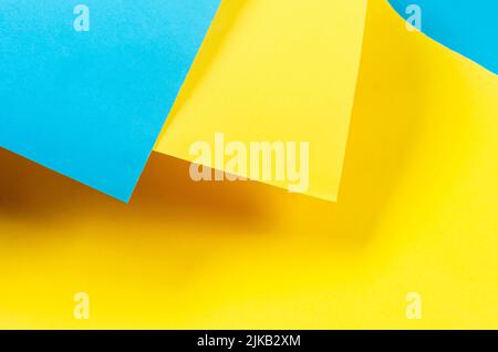 Color papers geometry flat composition background with yellow and blue tones. Colors symbols of Ukraine. Stock Photo