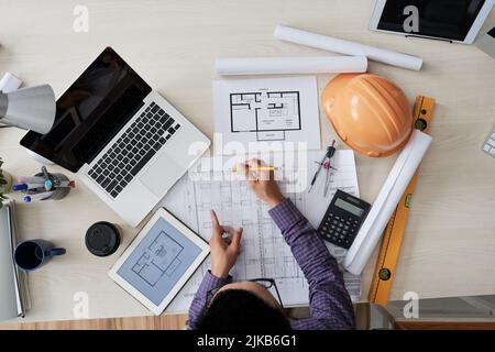Engineer working on blueprint of the building for new district, view from above Stock Photo