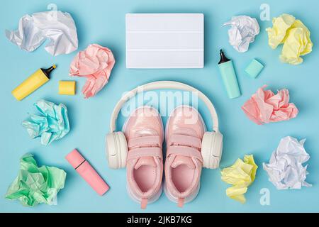 Blank lightbox. Headphones, pink shoes, colored crumpled paper balls, marker on blue background. Education concept. Flat Lay Top view Still life Mock Stock Photo