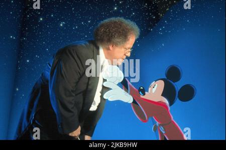 James Levine & Mickey Mouse Film: Fantasia 2000 (USA 1999) Characters: Himself - Host (segment 'Pomp and Circumstance'), Conductor (Chicago Symphony Orchestra) &  Director: Various 17 December 1999   **WARNING** This Photograph is for editorial use only and is the copyright of WALT DISNEY PICTURES and/or the Photographer assigned by the Film or Production Company and can only be reproduced by publications in conjunction with the promotion of the above Film. A Mandatory Credit To WALT DISNEY PICTURES is required. The Photographer should also be credited when known. No commercial use can be gran Stock Photo