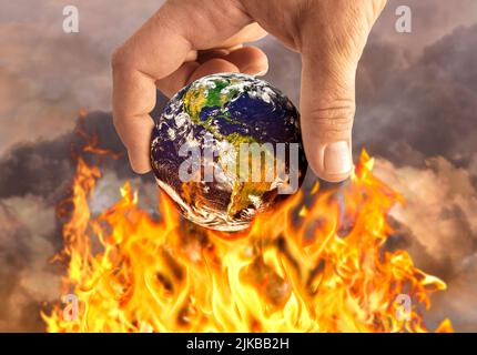 Human holding earth on fire, global warming conce Stock Photo