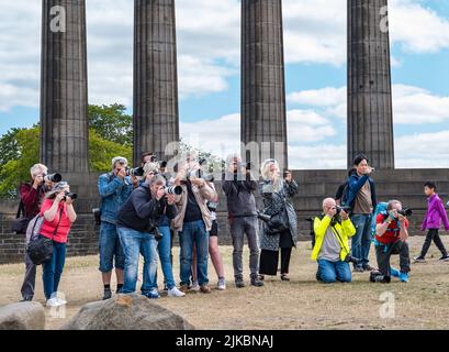 Edinburgh, Scotland, United Kingdom, 1st August 2022. Edinburgh Festival Fringe: the press pack of photographers take photos during a photocall joined by members of the public taking photos on Calton Hill beside the National Monument of Scotland Stock Photo
