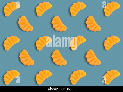 Jelly candies in shape of orange slice as pattern on blue background Stock Photo
