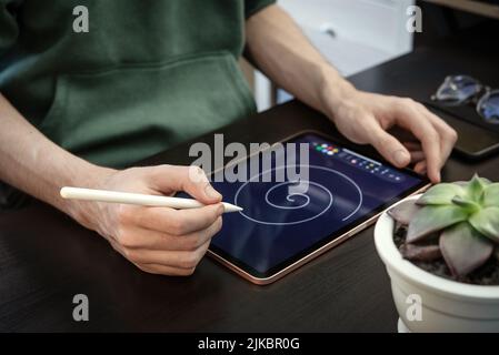 Man using digital tablet for drawing at home Stock Photo
