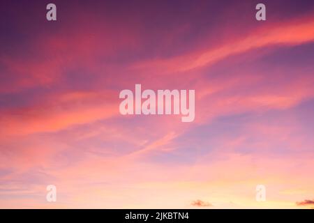 Bright colored sky during dusk hour with golden clouds reflecting the light of the twiligt sun. Background of white space, sky replacement. Stock Photo