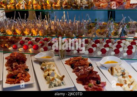 Catering service plate .appetizing sandwiches on plastic sticks rangeSandwiches on a table the buffet. meat, fish, vegetable canapes on a festive wedd Stock Photo